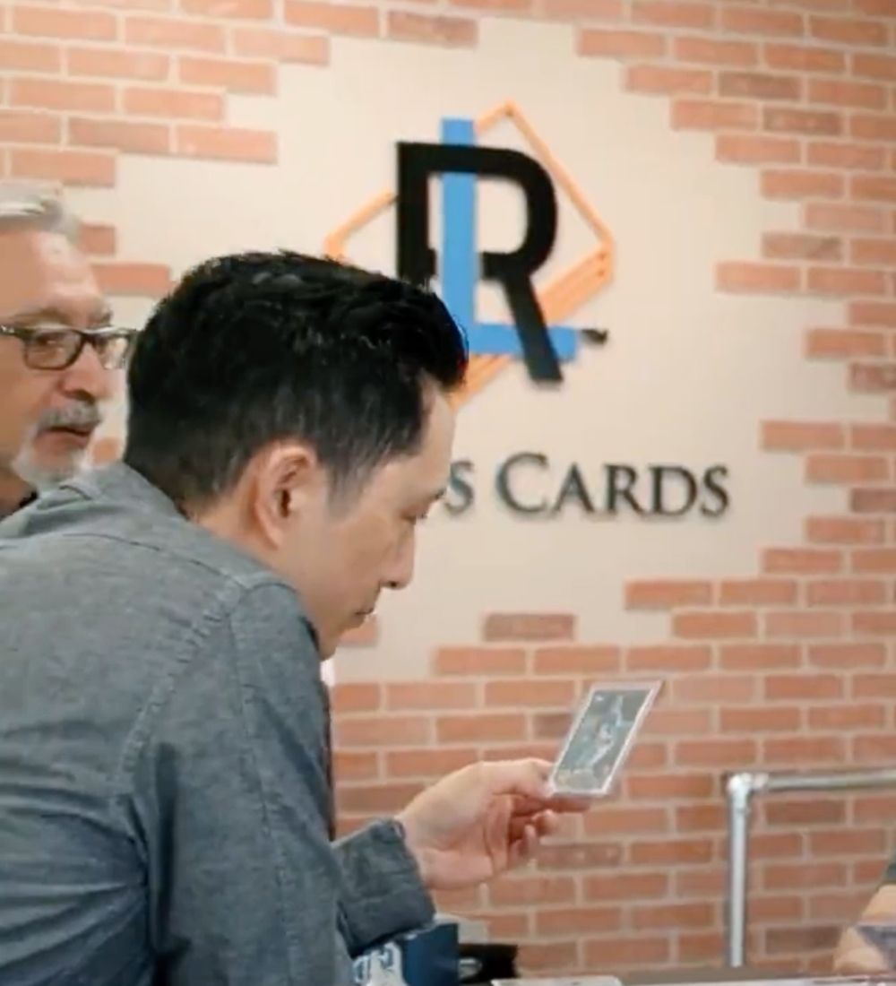 Man looking down at sports cards